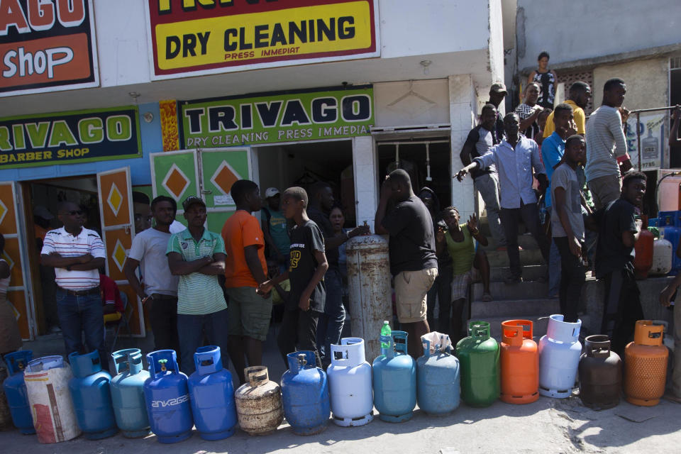 Residents line up to buy propane gas in Port-au-Prince, Haiti, Monday, Feb. 18, 2019. Businesses and government offices slowly reopened across Haiti on Monday after more than a week of violent demonstrations over prices that have doubled for food, gas and other basic goods in recent weeks and allegations of government corruption. (AP Photo/Dieu Nalio Chery)