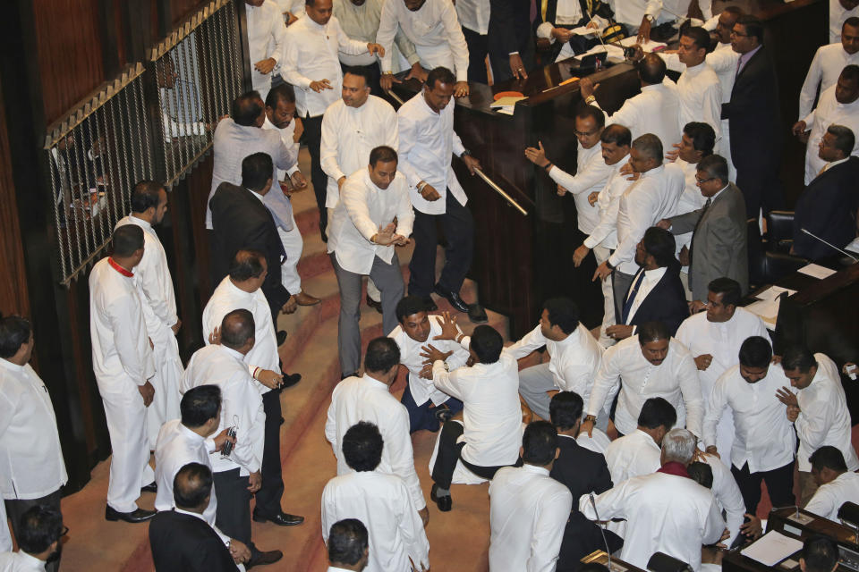 FILE - In this Nov. 15, 2018 file photo, Sri Lankan rival lawmakers fight inside the parliament chamber in Colombo, Sri Lanka. Government dysfunction and an intelligence failure that preceded the Easter Sunday bombings that killed 253 people in Sri Lanka are traced to simmering divisions between the president and prime minister after a weekslong political crisis that crippled the country last year. (AP Photo/Lahiru Harshana, File)