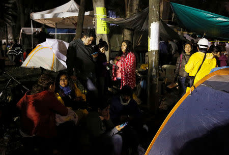 Relatives wait for news of their loved ones next to a collapsed building after an earthquake in Mexico City, Mexico September 22, 2017. REUTERS/Henry Romero