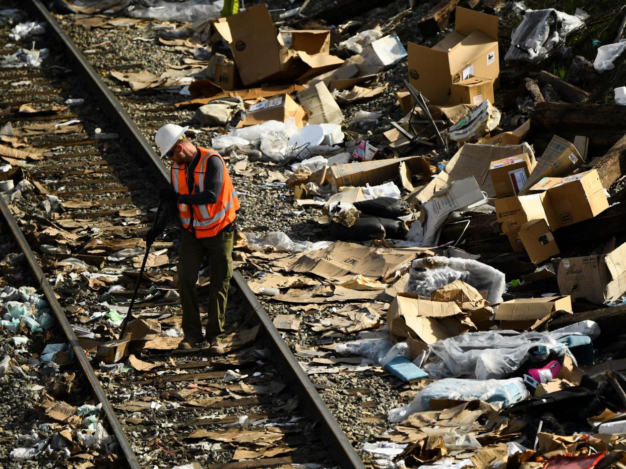 A railroad workers inspects a track as they repair a section of Union Pacific train tracks after a train derailed from the tracks, which are littered with thousands of opened boxes and packages stolen from cargo shipping containers targeted by thieves as the trains stop in downtown Los Angeles, California