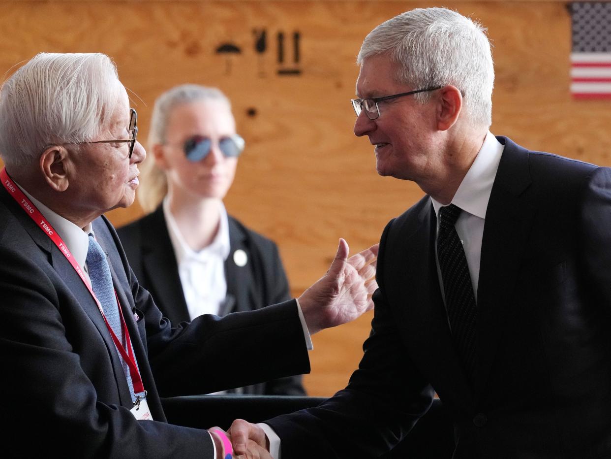 Taiwan Semiconductor Manufacturing Company founder Morris Chang, left, shakes hands with Apple CEO Tim Cook, right, at the TSMC facility under construction in Phoenix, Tuesday, Dec. 6, 2022.