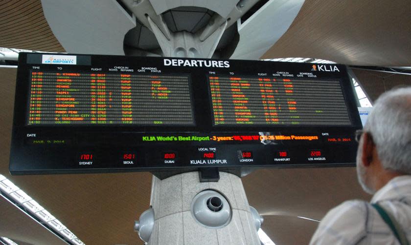 A man looking at the flight information board at the Kuala Lumpur International Airport (KLIA) in Sepang. MAHB said as many as 20 flights were delayed this morning due to a massive disruption of its systems. — Picture by Mohd Yusof Mat Isa