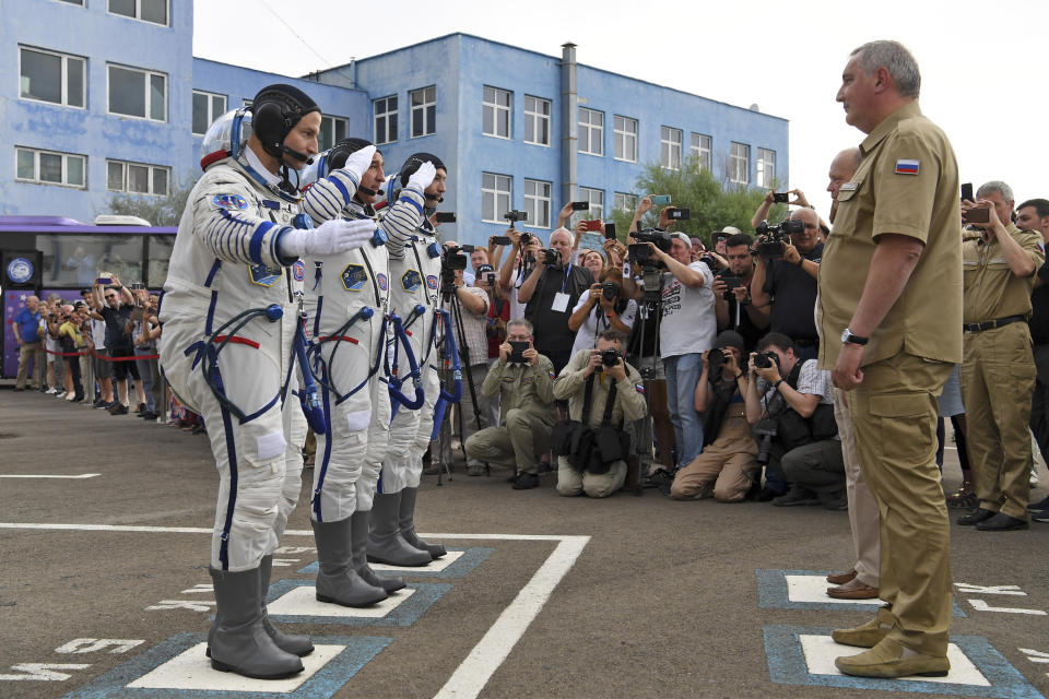 From left: U.S. astronaut Andrew Morgan, Russian cosmonaut Alexander Skvortsov and Italian astronaut Luca Parmitano, members of the main crew of the expedition to the International Space Station (ISS), report to head or Russian space agency Dmitry Rogozin prior the launch of Soyuz MS-13 space ship at the Russian leased Baikonur cosmodrome, Kazakhstan, Saturday, July 20, 2019. (AP Photo/Kirill Kudryavtsev, Pool)
