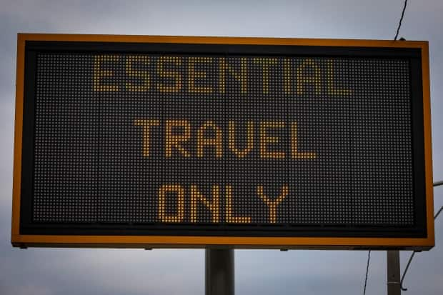 A road sign in Toronto in January informs drivers to travel only for essential reasons. Ontario remains in a state of emergency that includes orders to stay at home except for essential trips. (Evan Mitsui/CBC - image credit)