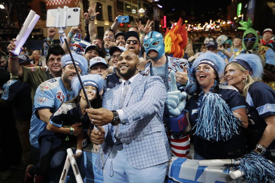 Tennessee Titans player Jurrell Casey takes a photo with fans on the main stage after announcing the Titans selection of North Carolina-Charlotte guard Nate Davis during the third round of the NFL football draft, Friday, April 26, 2019, in Nashville, Tenn. (AP Photo/Mark Humphrey)