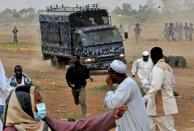 Sudanese protesters run for cover as riot policemen try to disperse them during a protest against an amateur film mocking Islam outside the US embassy in Khartoum