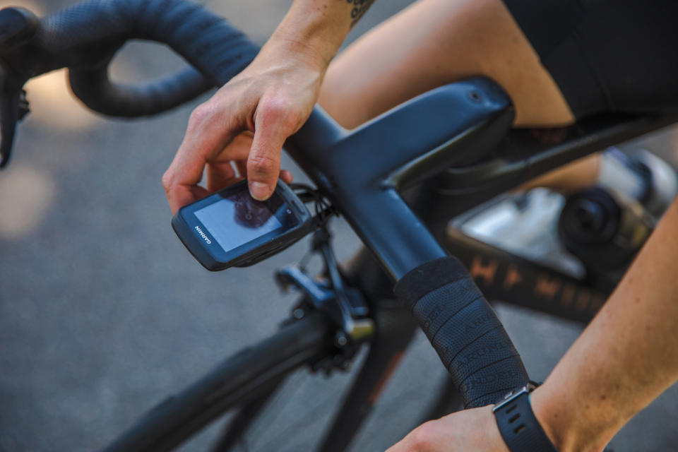 Female cyclist looking at her cycling computer that's mounted on her bike