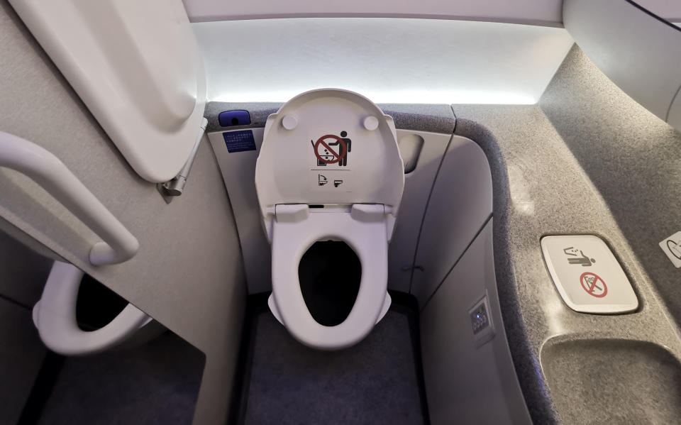 A small space showing an airplane toilet. 