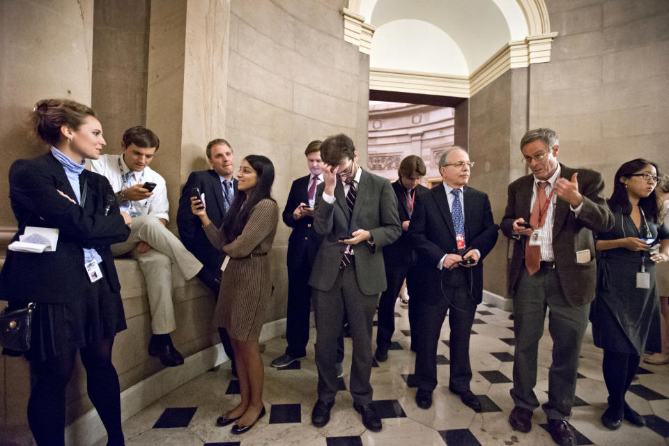 Reporters wait outside the office of Speaker of the House John Boehner, R-Ohio, as a planned vote in the House of Representatives collapsed, Tuesday night, Oct. 15, 2013, at the Capitol in Washington. (AP Photo/J. Scott Applewhite)