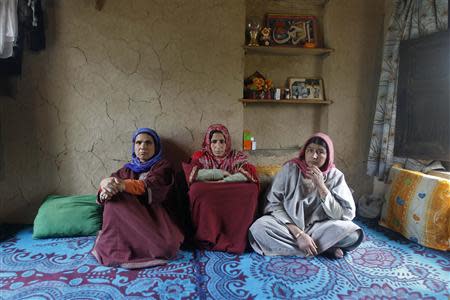 Saheema Akhtar (C), wife of Mohammed Amin Pandith, a village council head, who was killed by militants, sits with relatives inside her house in Gulzarpora, south of Srinagar April 23, 2014. REUTERS/Danish Ismail