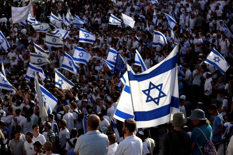 FILE PHOTO: Israelis carry flags during a march marking Jerusalem Day, the anniversary of Israel's capture of East Jerusalem during the 1967 Middle East war, near Damascus Gate outside Jerusalem's Old City