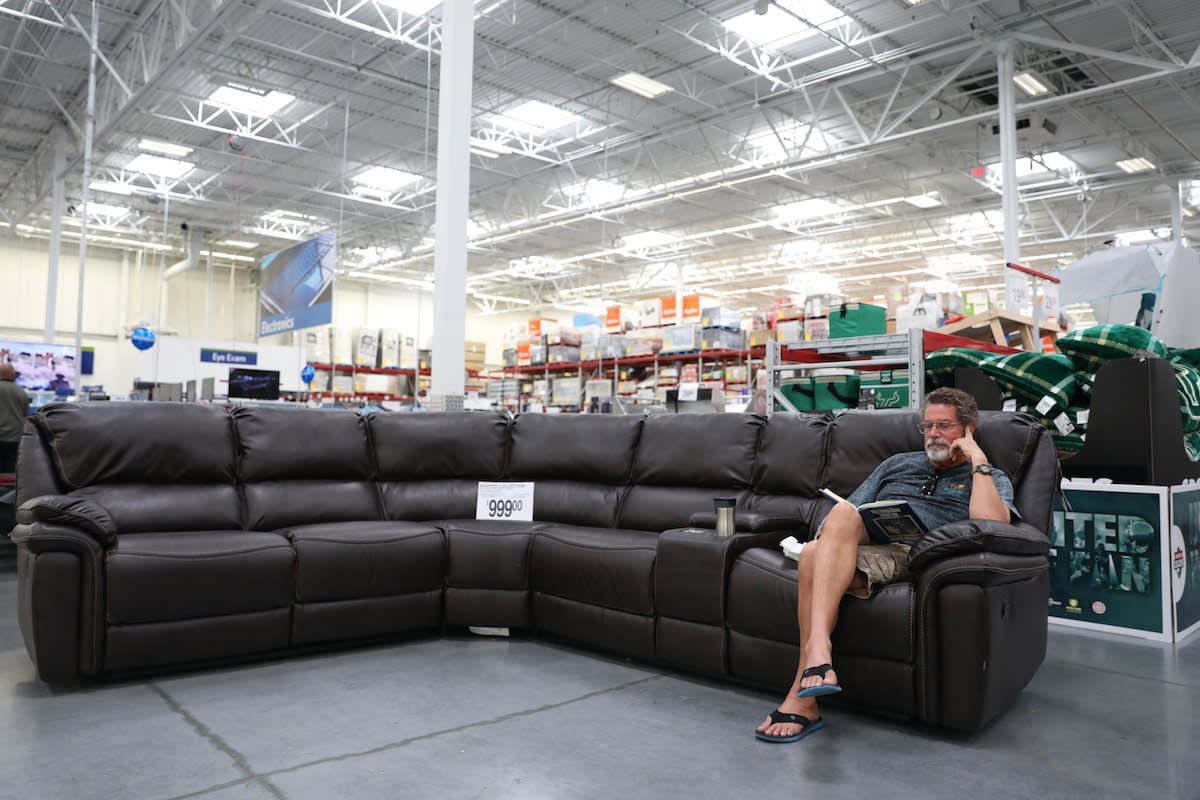 Ben Fulle reads on a sofa for sale at Sam's Club in St. Petersburg, Fla., as his car which was being serviced on Wednesday August 16, 2017.