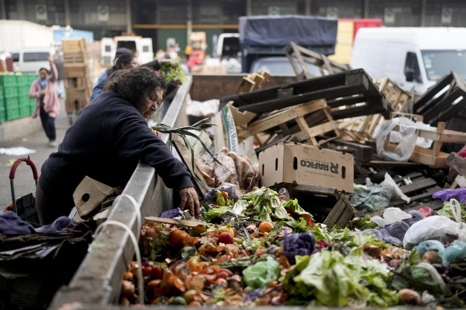 FILE - A woman reaches in a bin of discarded produce outside a market in Buenos Aires, Argentina, Sept. 1, 2023. Runaway inflation has taken its toll across the country. Compared to August of last year, prices rose 124%, according to figures released by the government's Indec statistics agency. (AP Photo/Natacha Pisarenko, File)