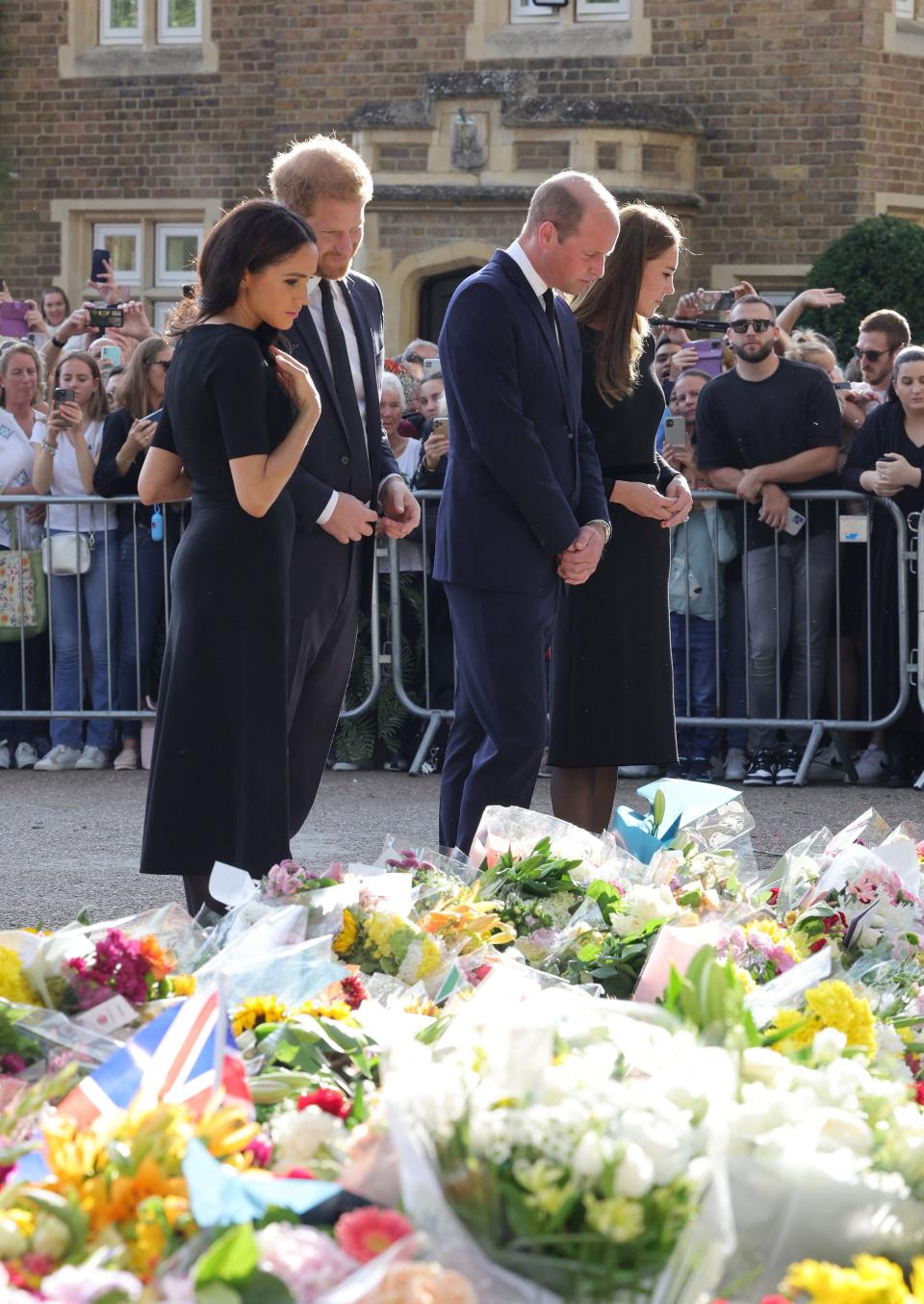 <p>From left: Meghan, Duchess of Sussex; Prince Harry, Duke of Sussex; Prince William, Prince of Wales; and Catherine, Princess of Wales look at floral tributes laid by members of the public on their walkabout at Windsor Castle on Sept. 10, 2022 before meeting well-wishers. (Photo by Chris Jackson/Pool/AFP via Getty Images)</p> 