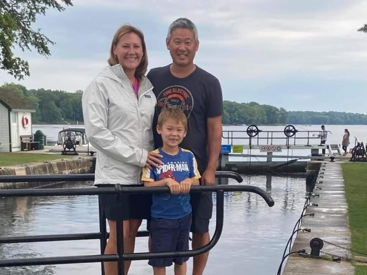 Rob Hayami (right) poses with his wife Kristine McGillivray and his son Owen. Hayami died Wednesday after being injured in the powerful storm that hit Ottawa on May 21. He was 49. (Submitted by Steve Hamre - image credit)