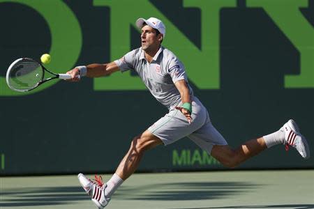 Mar 26, 2014; Miami, FL, USA; Novak Djokovic hits a forehand against Andy Murray (not pictured) on day ten of the Sony Open at Crandon Tennis Center. Mandatory Credit: Geoff Burke-USA TODAY Sports