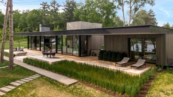 The home is crafted from glass, timber, and steel—a simple yet refined palette that complements the spectacular natural setting. The deck is surrounded by lush planting that further integrates the built form into the landscape and offers a green outlook from inside, while a 