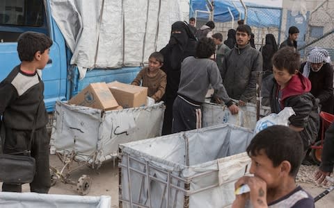 Children collect goods from an aid distribution at a camp for people who lived under ISIS and are now displaced, in Al Hol, near Hasakeh in Syria - Credit: Sam Tarling/The Telegraph