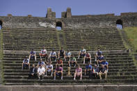 Cyclists sit by The Giro d'Italia trophy at the archaeological area of Pompeii, Italy, ahead of the 10th stage of the Giro d'Italia, Tour of Italy cycling race, from Pompei to Cusano Mutri, Tuesday, May 14, 2024. (Marco Alpozzi/LaPresse via AP)