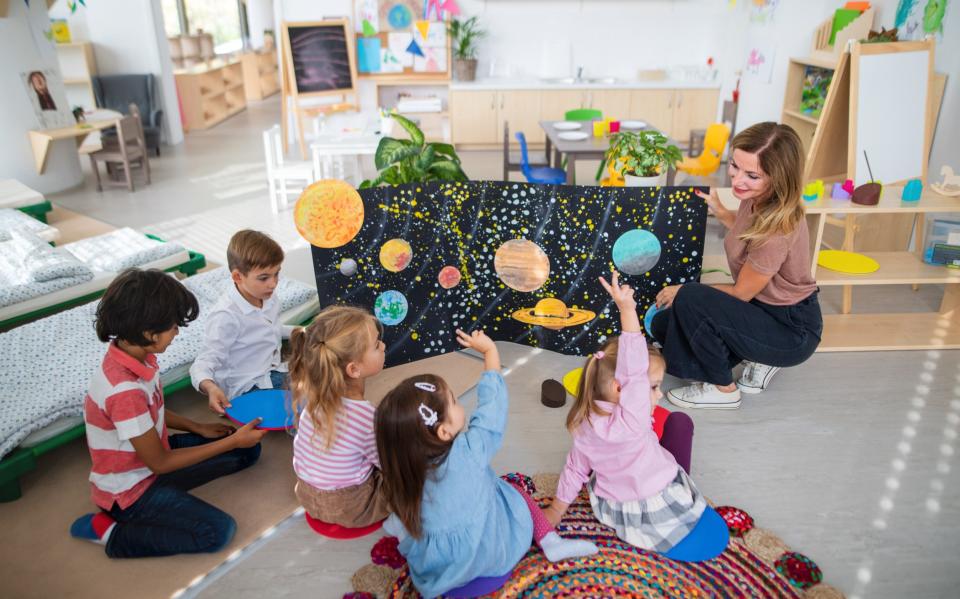 A teacher with pupils in a nursery school class