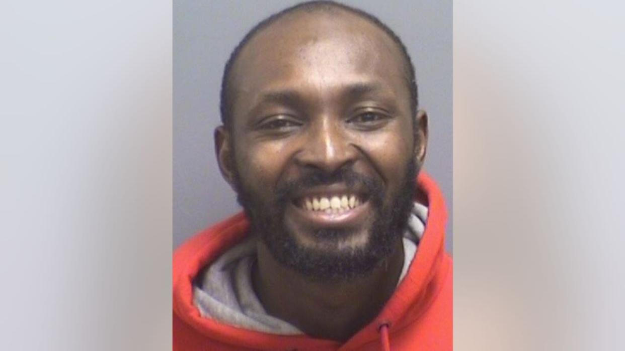 Owusu Sakyi smiling in his mugshot