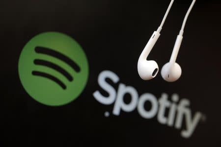 Headphones are seen in front of a logo of online music streaming service Spotify in this illustration picture taken in Strasbourg, February 18, 2014. REUTERS/Christian Hartmann