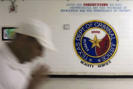 An offender walks past a sign on a wall at the the Darrington Unit of the Texas Department of Criminal Justice men's prison in Rosharon, Texas August 12, 2014. REUTERS/Adrees Latif