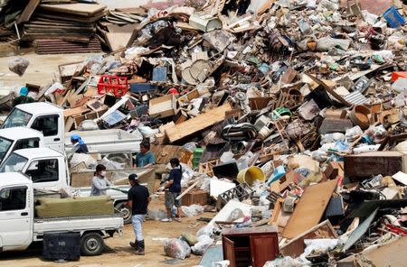 Local residents pile up household waste, caused by a flooding, at a temporary waste-collection point at Mabi Clean Center in Kurashiki, Okayama Prefecture, Japan, July 13, 2018. REUTERS/Issei Kato