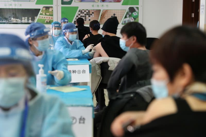 Medical workers administer COVID-19 vaccine at a makeshift vaccination site in Beijing