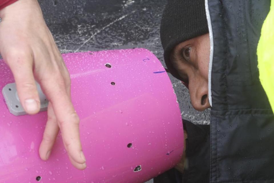 This May 4, 2022, photo shows engineer Ehsan Abdi looking from the other end as a sensor is placed inside an underwater glider on the University of Alaska Fairbanks research vessel Nanuq in the Gulf of Alaska. The glider was fitted with special sensors to study ocean acidification. (AP Photo/Mark Thiessen)