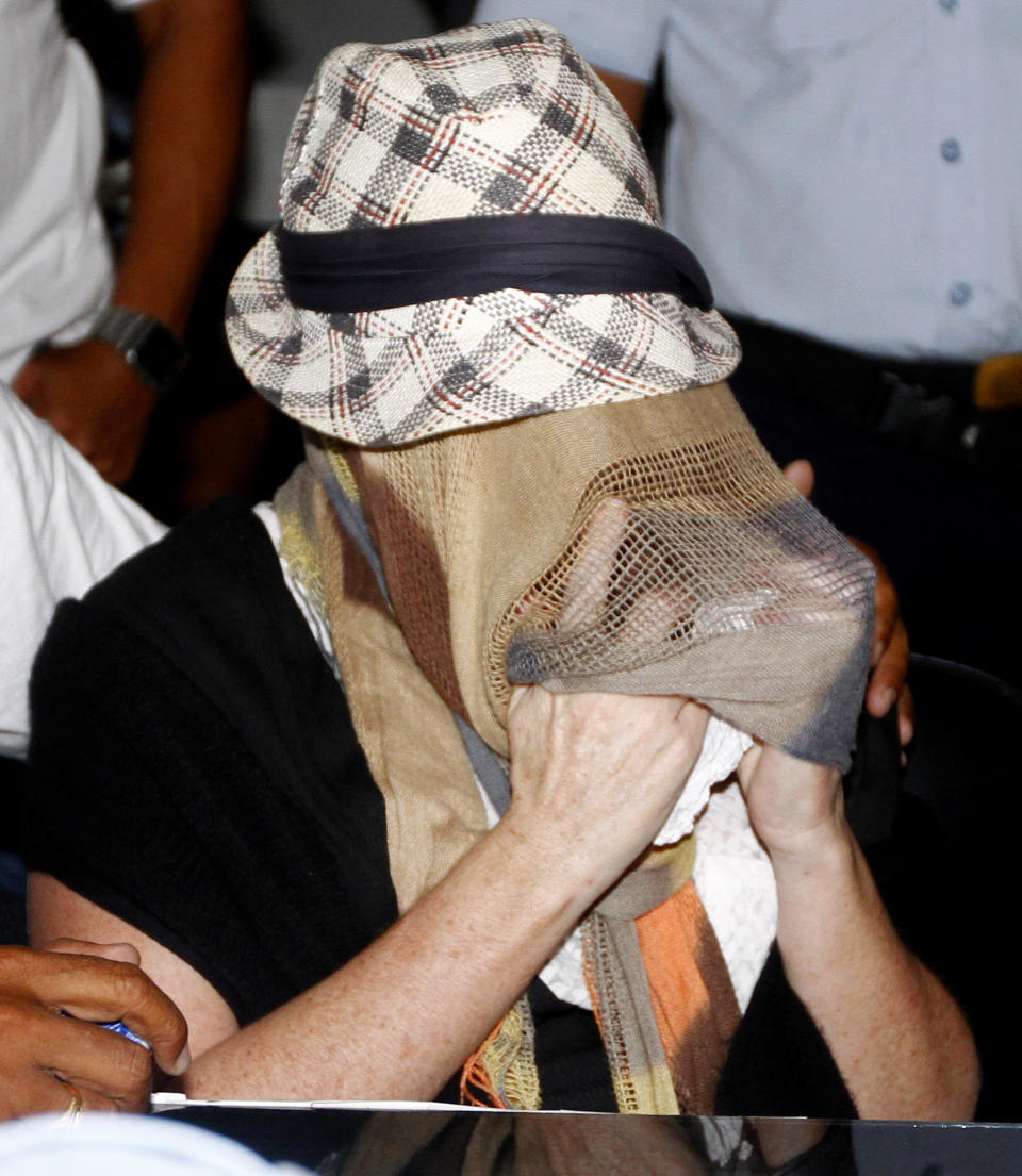 Australian Schapelle Corby, covering her face, gestures at the correctional office after she received her parole in Bali, Indonesia, Monday, Feb. 10, 2014. The Australian woman convicted of smuggling marijuana into Indonesia in 2005 has been released from jail on parole. She was convicted of smuggling 4.2 kilograms (9 pounds) of marijuana onto Bali and sentenced to 20 years in prison. (AP Photo/Firdia Lisnawati)