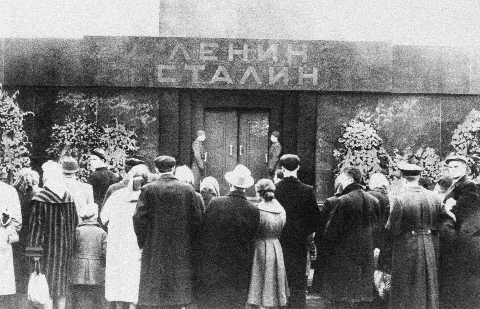 FILE - Russians gather in front of the Lenin mausoleum with the names reading "Lenin, Stalin" on the top after completion of alterations involving the removal of stone bearing Stalin's name in Red Square in Moscow, Russia in March 7, 1962. In a speech to a Communist Party congress, he railed for hours against Stalin, decrying his brutality and denouncing the “cult of personality” he engendered. He later ordered Stalin's body removed from the Red Square mausoleum where Lenin's body also lay. (AP Photo/Reinhold Ensz, File)