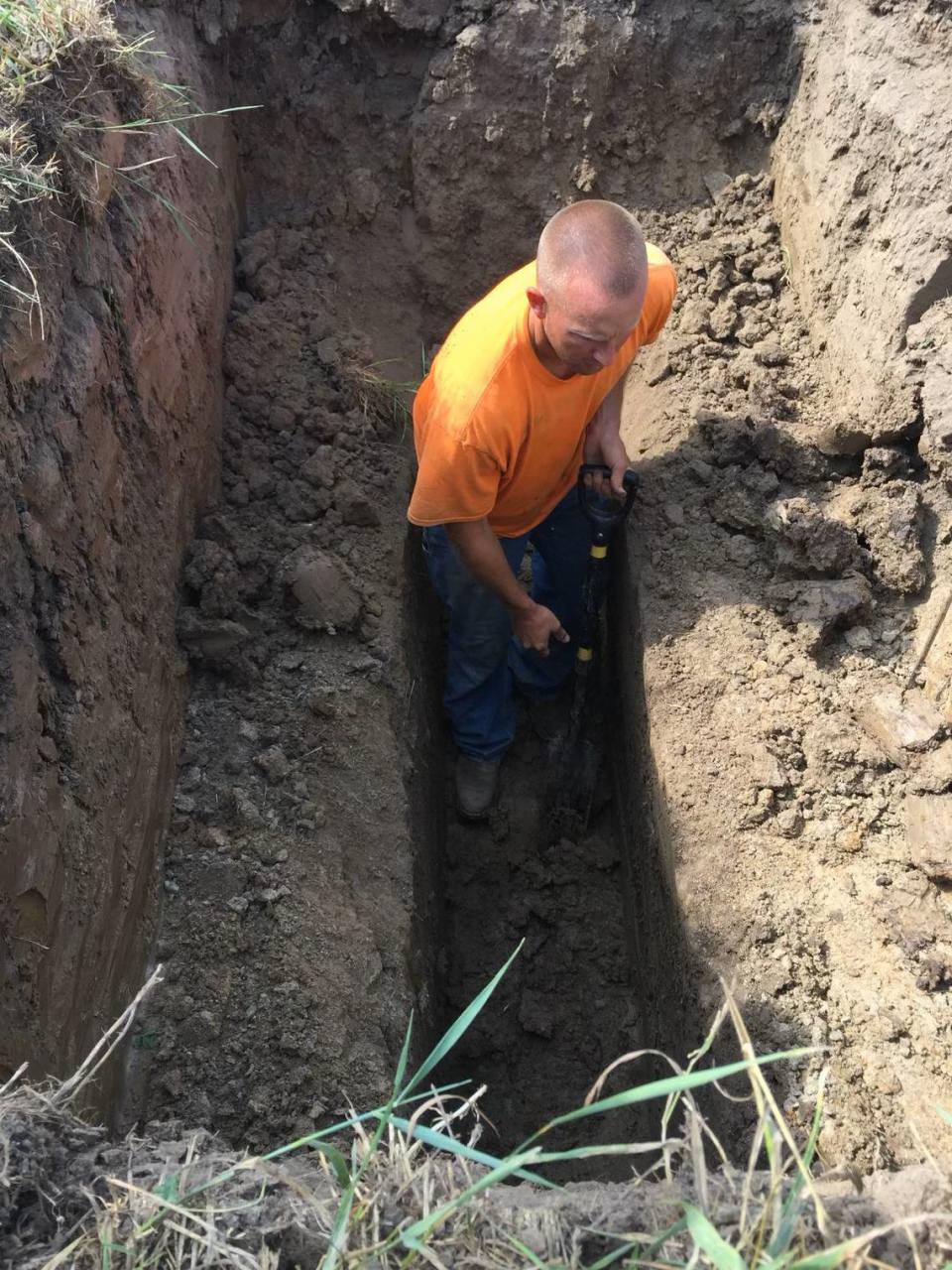 Harold Beach’s son, Chris Beach, sets up a trench before laying drainage tile. Beach said drainage tile significantly improved his crop yields.