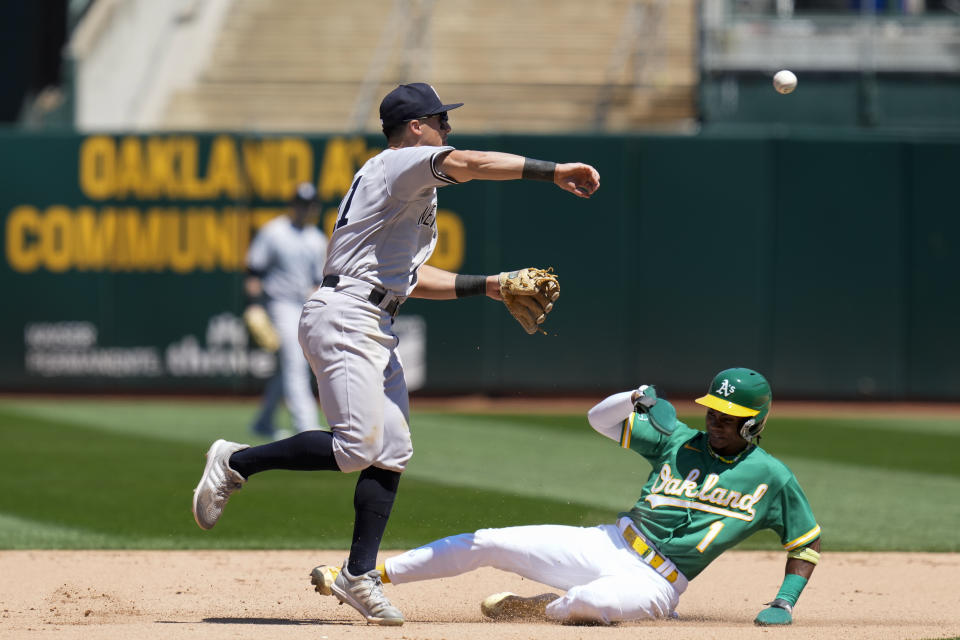 New York Yankees shortstop Anthony Volpe, left, throws to first for a double play as Oakland Athletics' Esteury Ruiz (1) slides during the seventh inning of a baseball game in Oakland, Calif., Thursday, June 29, 2023. Tony Kemp was out at first. (AP Photo/Godofredo A. Vásquez)