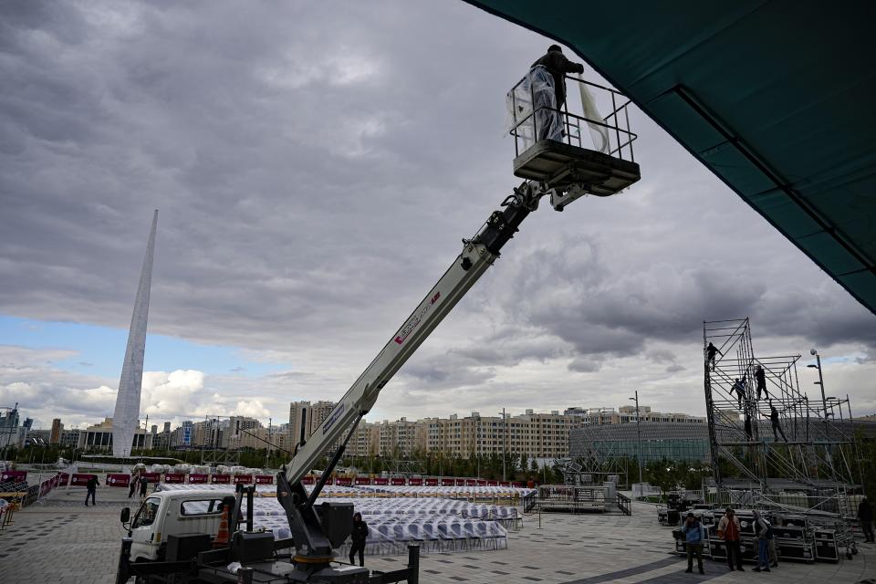 Municipal workers prepare the square for a Holy Mass with Pope Francis' attending in Nur-Sultan, the capital of Kazakhstan, Monday, Sept. 12, 2022. Pope Francis is going to the majority-Muslim former Soviet republic on Tuesday to minister to its tiny Catholic community and participate in a Kazakh-sponsored conference of world religious leaders. (AP Photo/Alexander Zemlianichenko)