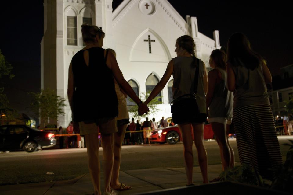 People gather outside the Emanuel AME Church in Charleston, South Carolina on June 18, 2015. Police captured the white suspect, 21-year-old Dylann Roof, the main suspect in a gun massacre at one of the oldest black churches in the United States, the latest deadly assault to feed simmering racial tensions. AFP PHOTO/BRENDAN SMIALOWSKI        (Photo credit should read BRENDAN SMIALOWSKI/AFP/Getty Images)