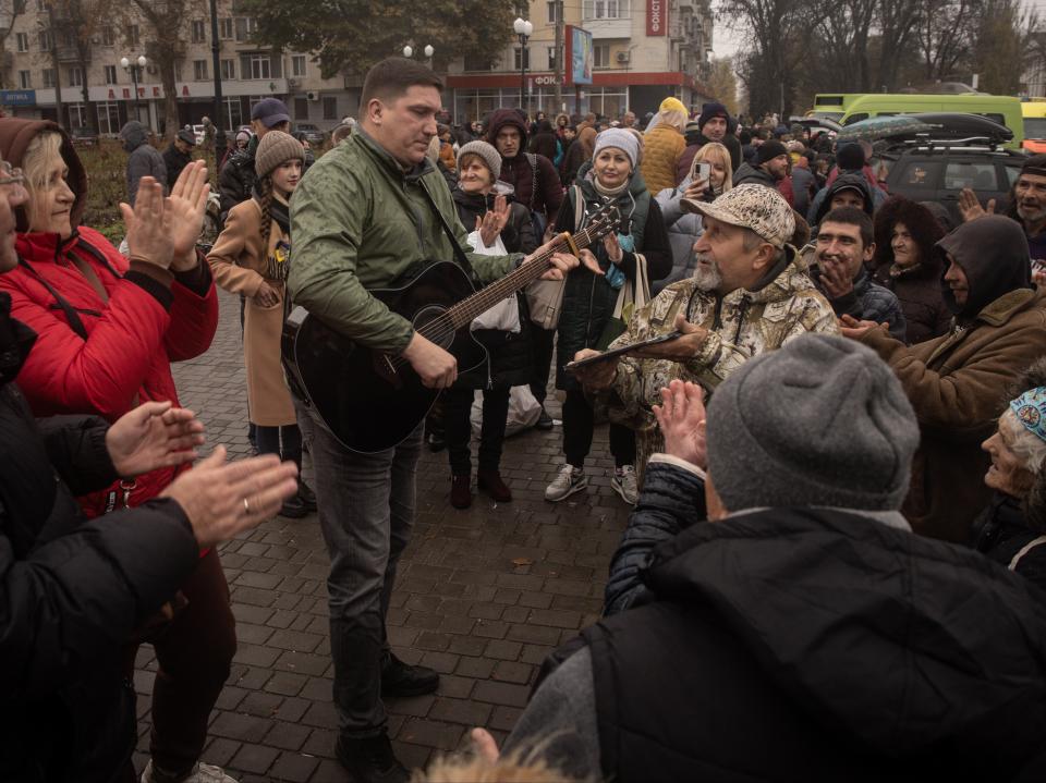 A man plays guitar and sings songs to residents in Kherson (Getty Images)