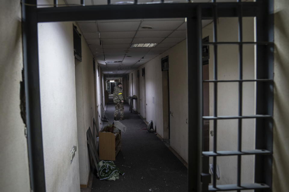 A Ukrainian serviceman walks in the corridor of a basement in a building used, according to a war crime prosecutor, by Russian forces as a place of torture in Kherson, Ukraine, Thursday, Dec. 8, 2022. (AP Photo/Evgeniy Maloletka)