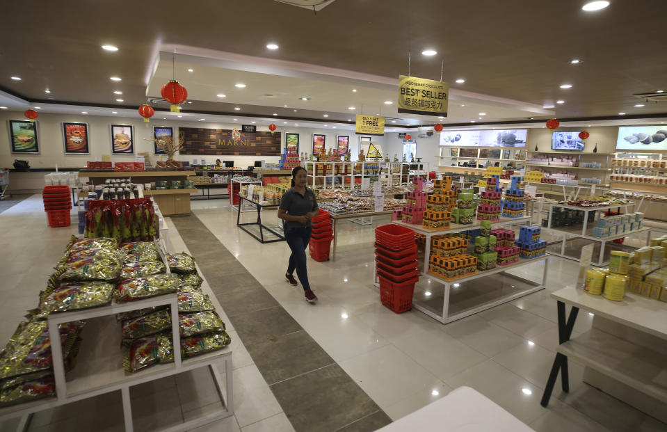 A worker walks through an empty Marni super market on the popular tourist island of Bali, Indonesia on Wednesday, Jan. 18, 2023. A hoped-for boom in Chinese tourism in Asia over next week's Lunar New Year holidays looks set to be more of a blip as most travelers opt to stay inside China if they go anywhere. (AP Photo/Firdia Lisnawati)