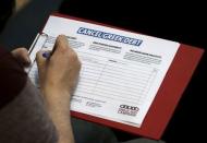 A man adds his name to a petition to cancel Greek debt during a rally in support of Greece at the TUC's Congress House, in London, Britain, July 6, 2015. REUTERS/Peter Nicholls