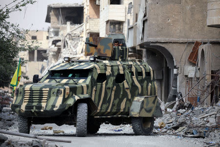 A fighter from Syrian Democratic Forces (SDF) sits in a military tank in Raqqa, Syria September 16, 2017. REUTERS/ Rodi Said