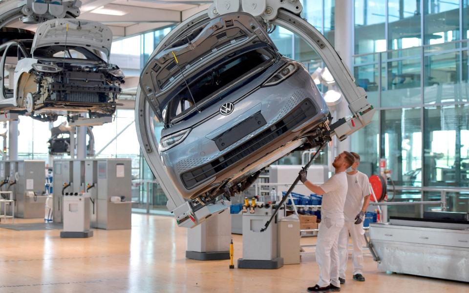 Technicians work on the assembly line of German carmaker Volkswagen's electric ID - REUTERS/Matthias Rietschel/File Photo