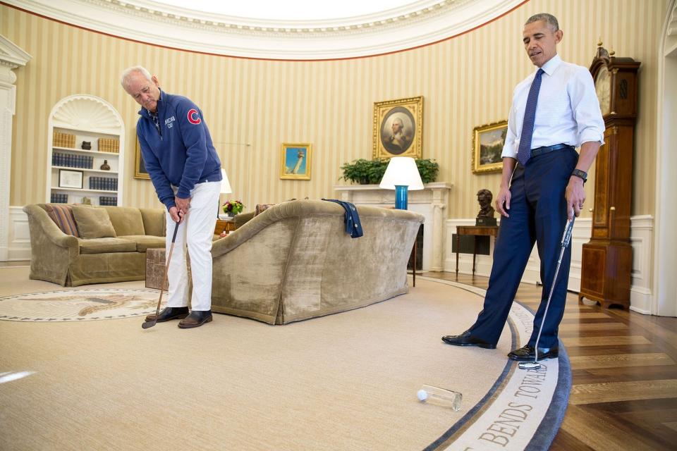 Actor Bill Murray putts into a glass in the Oval Office after stopping by to be honored as the recipient of the Mark Twain Prize for American Humor on Oct. 21.