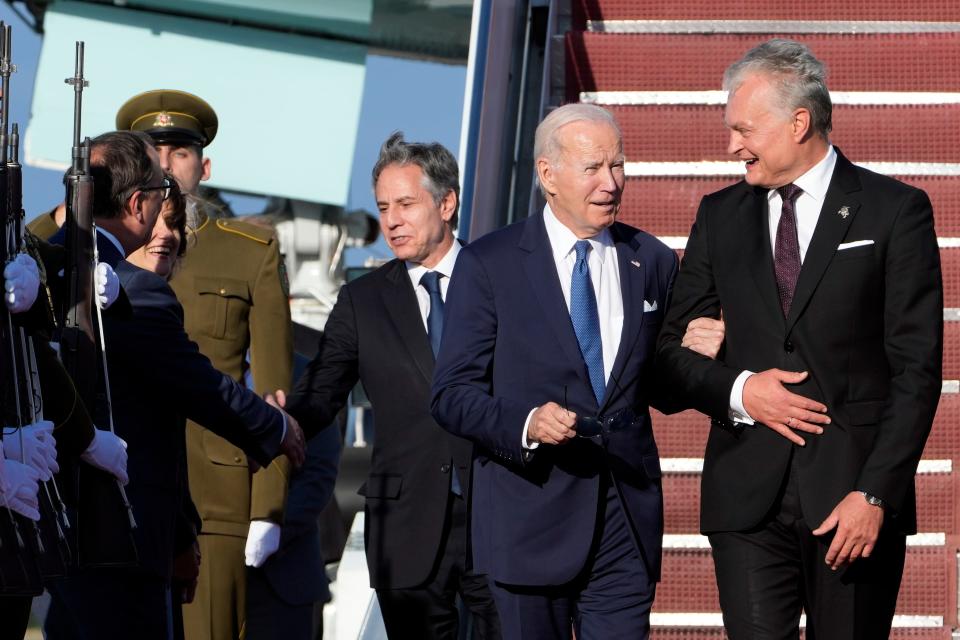 President Joe Biden talks with Lithuania's President Gitanas Nauseda, right, as he arrives at Vilnius International Airport with Secretary of State Antony Blinken, third from right, in Vilnius, Lithuania, Monday, July 10, 2023. Biden is in Lithuania to attend the NATO Summit.