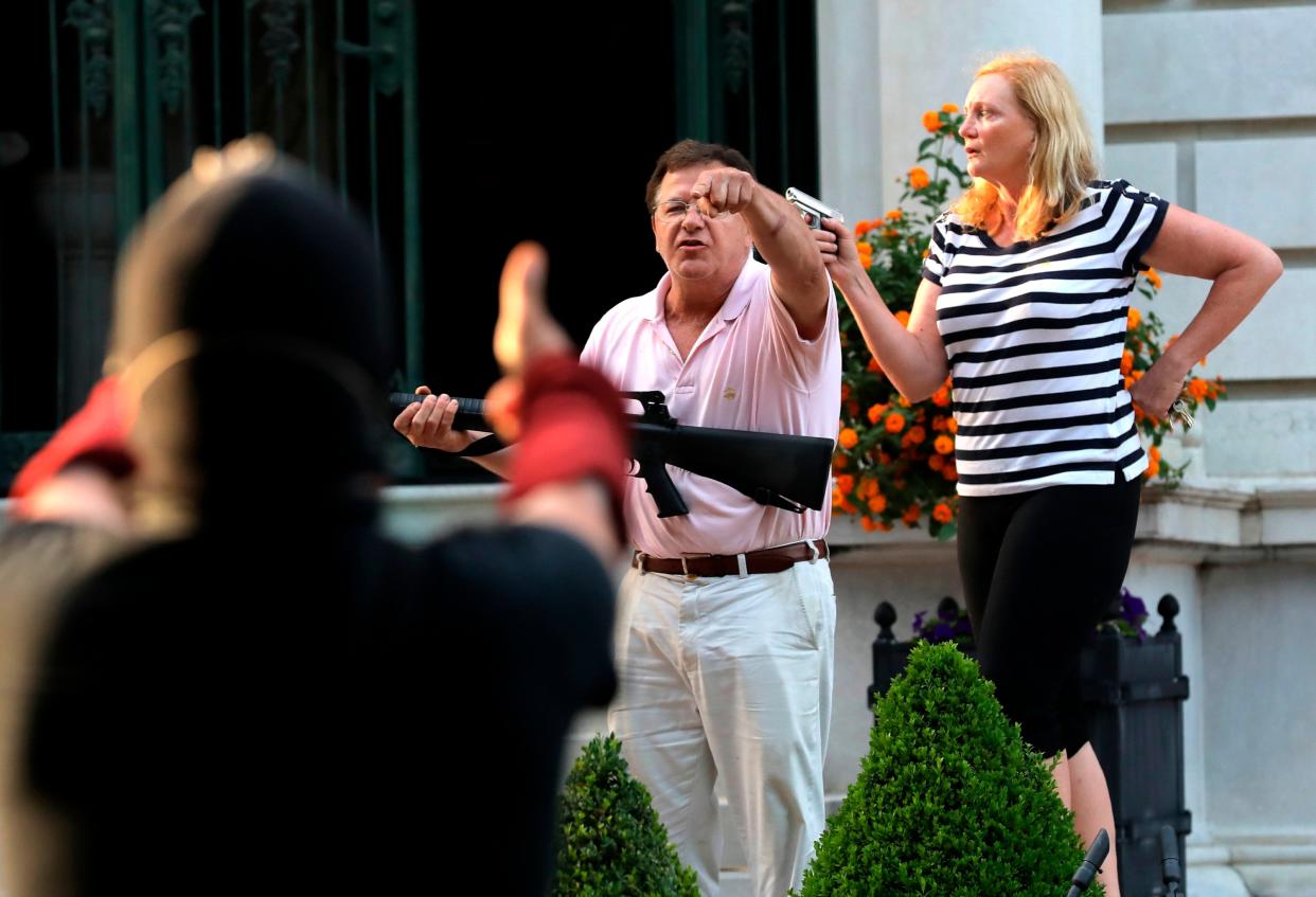 Armed homeowners Mark and Patricia McCloskey confront Black Lives Matter protesters in St Louis on 28 June, 2020 (AP)