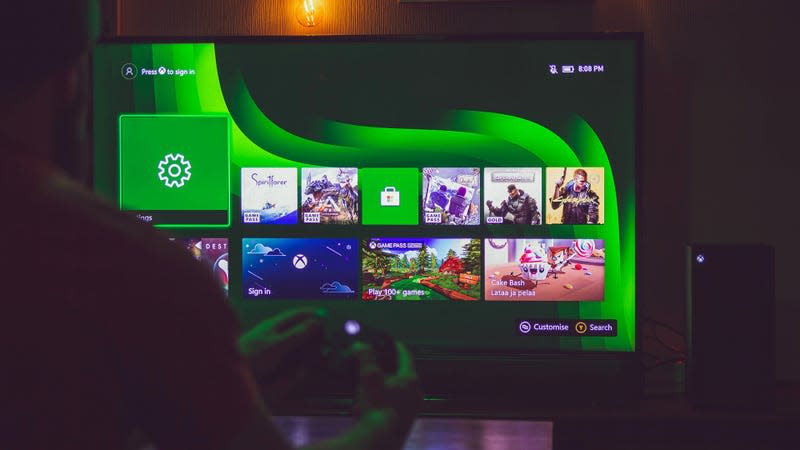 A person sits in front of a TV with an Xbox Series X attached.