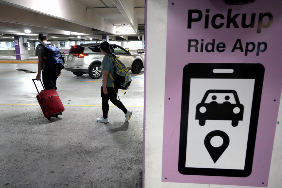 Travelers enter a pick up location for ride-hailing companies, Tuesday, July 9, 2024, in the lower level of a parking garage at Logan International Airport, in Boston. Drivers for ride-hailing companies in Massachusetts are pushing ahead with what they describe as a first-of-its-kind ballot question that would win union rights if approved. (AP Photo/Steven Senne)