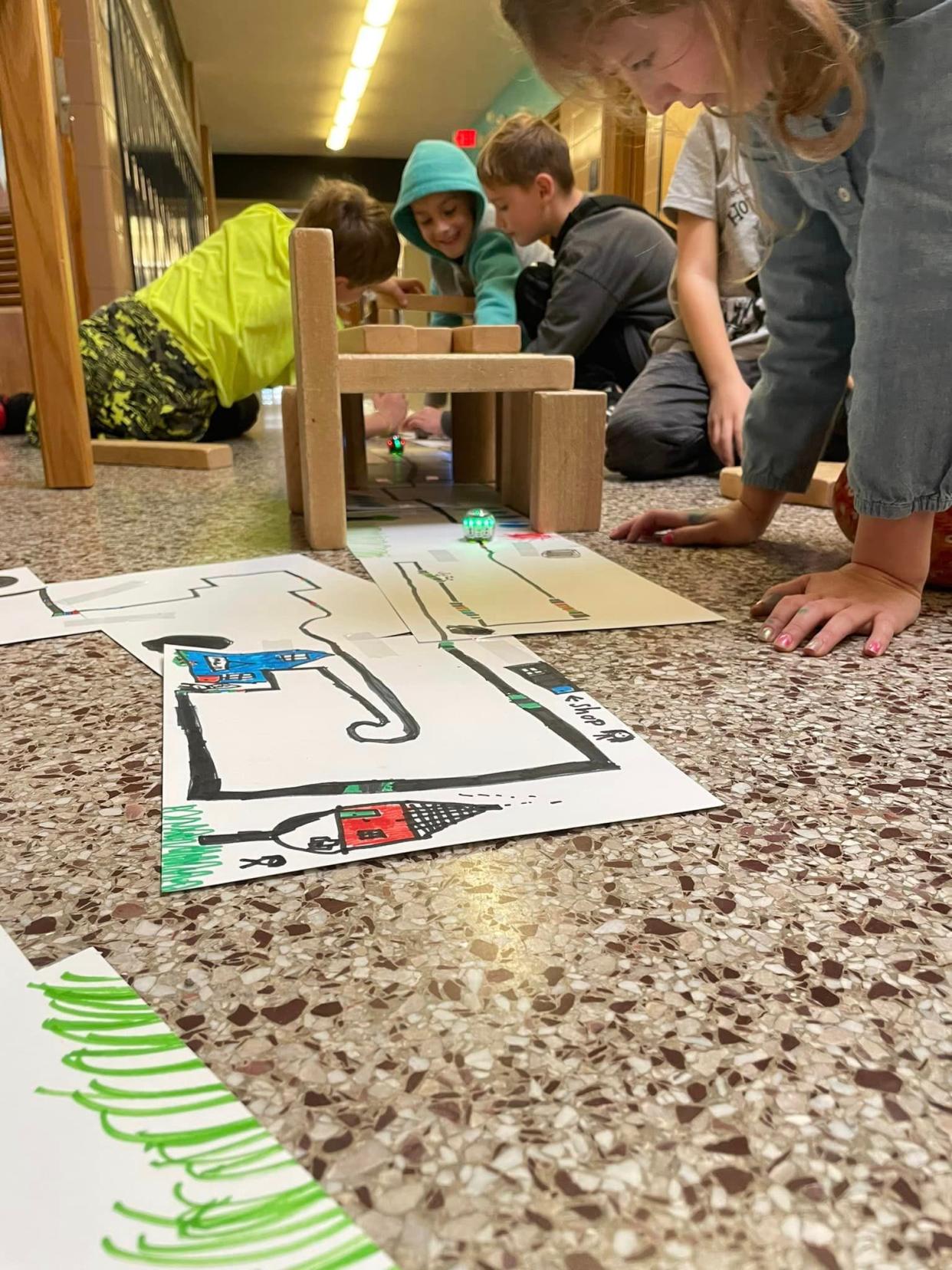 Second graders, from left, Owen Kane, Jacob Snyder, Ryan Waters and Ellie Newnum collaborate by creating sections of a "neighborhood" that allowed an OzoBot to travel and discover different locations. This project helps students learn about new places and people in social studies.