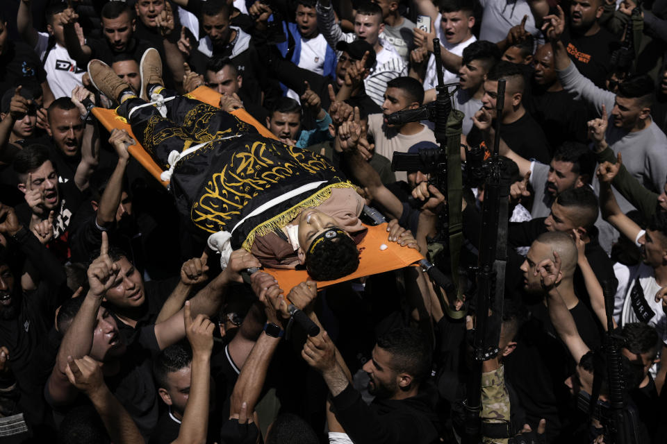 Mourners carry Ahmed Assaf, 19, draped in the flag of Islamic Jihad, two Palestinians killed by Israeli forces in Qabatiya, near the West Bank city of Jenin, Wednesday, May 10, 2023. The Israeli military said that Palestinian gunmen opened fire at troops in the Palestinian town of Qabatiya in the northern West Bank during an army raid. Troops returned fire, killing the two men, and confiscated their firearms, it said. (AP Photo/Majdi Mohammed)