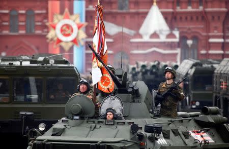 Russian servicemen stand atop a tank during the 72nd anniversary of the end of World War II on the Red Square in Moscow. REUTERS/Maxim Shemetov